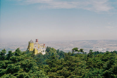 Scenic view of trees and buildings against sky