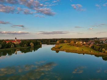 Scenic view of lake by buildings against sky