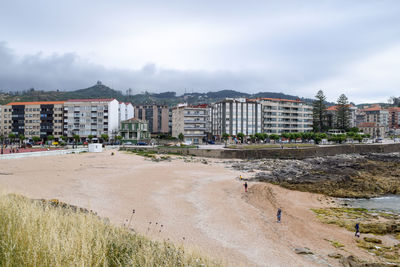 Buildings by sea against sky in city