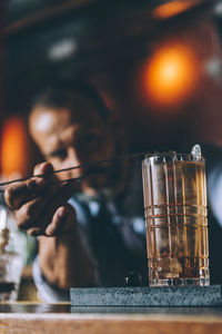 Close-up of bartender making drink on counter in bar