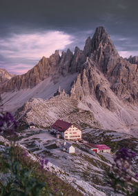 Houses by mountains against sky during sunset