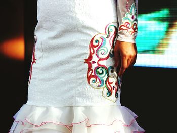 Midsection of woman in white dress with embroidery