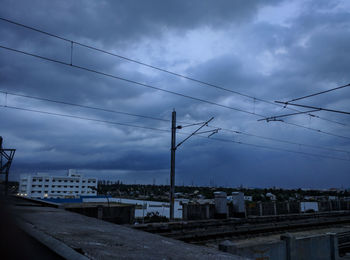 Electricity pylon against cloudy sky