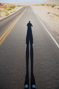 Shadow of man on road