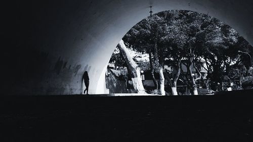 Silhouette people standing in tunnel