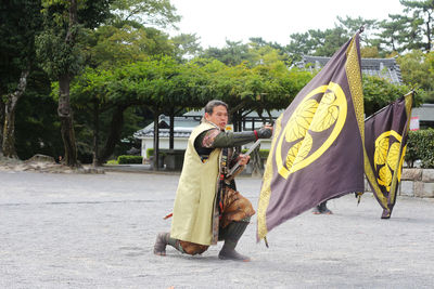 Man with arms raised against trees