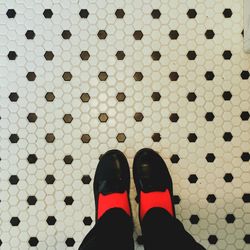 Low section of person standing on tiled floor