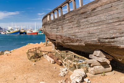 Fishing boats moored at harbor against sky