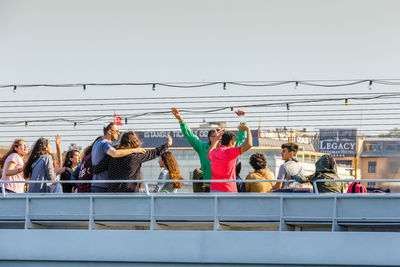 Group of people at music concert against clear sky