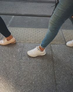 Low section of woman standing on tiled floor