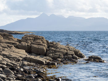 Scenic view of sea and mountains against sky