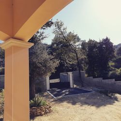 Built structure by trees against sky on sunny day