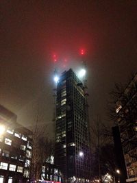 Low angle view of illuminated city against sky at night