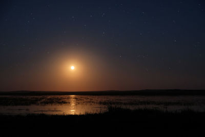 Scenic view of lake against sky at night