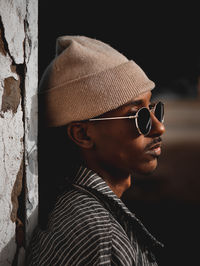 Young man wearing knit hat by wall