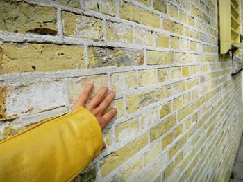 Close-up of human hand on stone wall