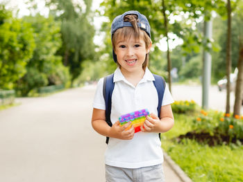 Little boy plays square rubber fidget toy pop it. rainbow-colored anti stress toy for all ages.