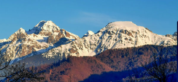 Scenic view of snowcapped mountains against clear blue sky