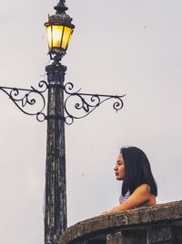 Low angle view of woman standing against clear sky