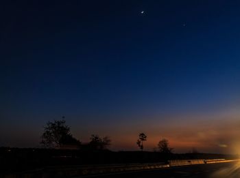 Silhouette trees against sky at night