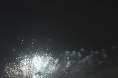 Low angle view of firework display at night