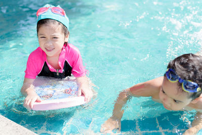 Happy girl playing in swimming pool