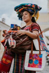 Low angle view of woman holding colorful umbrella