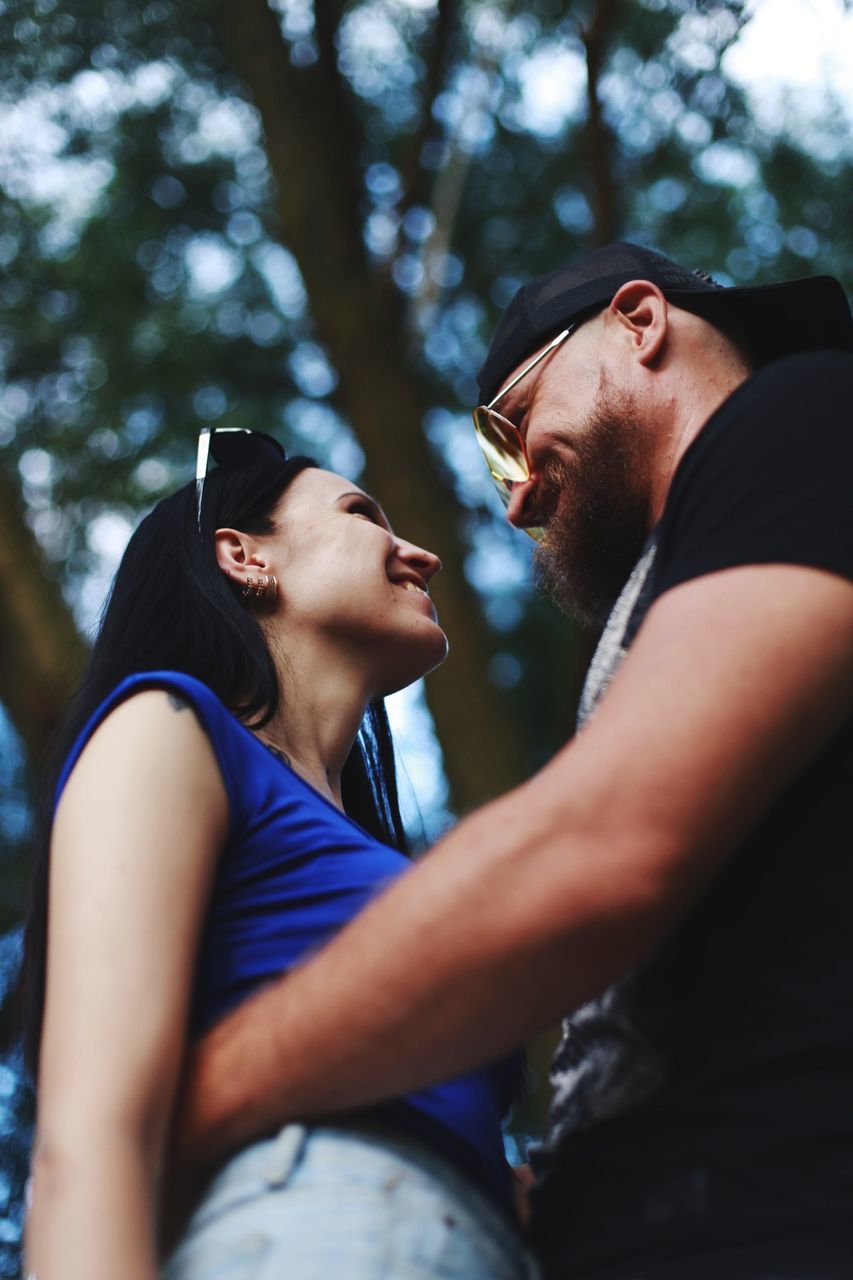 two people, adult, men, young adult, togetherness, emotion, side view, blue, tree, women, love, ceremony, romance, lifestyles, person, positive emotion, nature, casual clothing, outdoors, happiness, day, leisure activity, friendship, bonding, plant, forest, clothing, relaxation, smiling