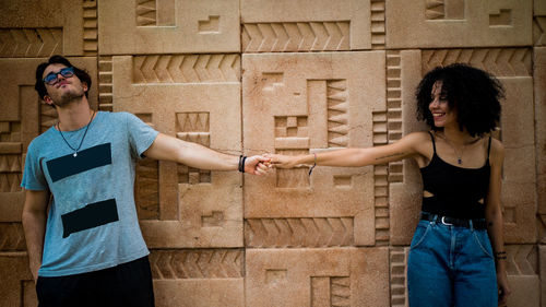 Young woman standing against the wall