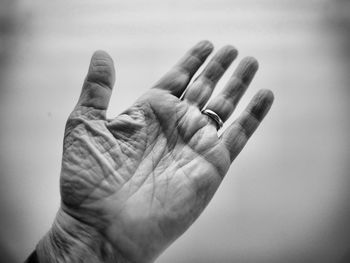 Close-up of wrinkled hand against white background