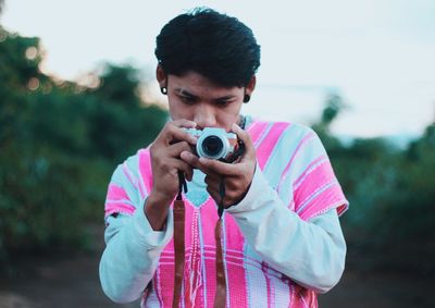 Young man photographing through camera