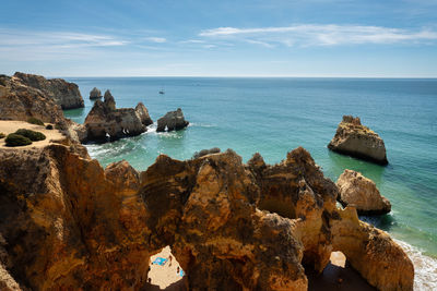 Panoramic view of rocks on beach against sky