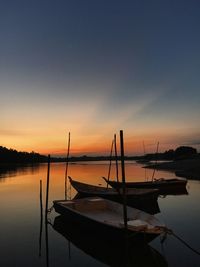 Boats in sea at sunset