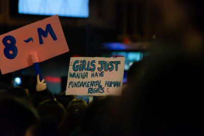 People holding placards with text during protest at night