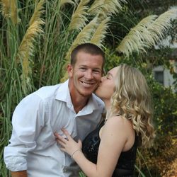 Daughter kissing happy father against trees