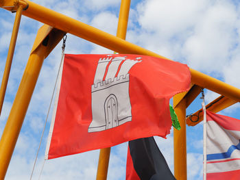 Low angle view of flags hanging against sky