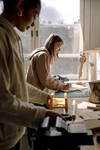 Side view of female teenage students learning during carpentry class