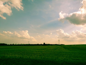 Scenic view of field against cloudy sky