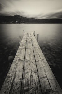 Close-up of pier over lake against sky