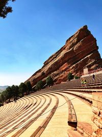 Amphitheatre and rock formation against blue sky