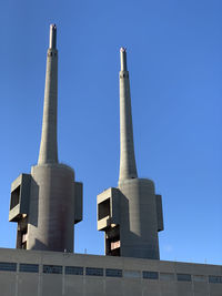 Low angle view of factory against blue sky