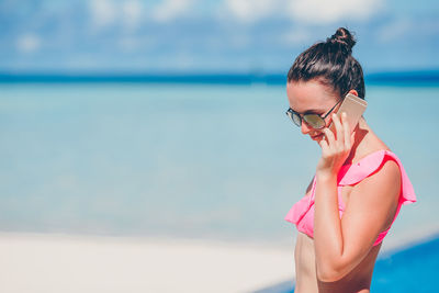 Side view of young woman standing at beach
