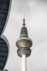 Low angle view of communications tower and buildings against sky