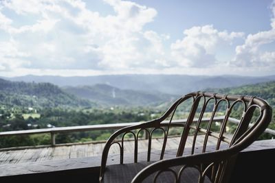 Metallic railing against mountain range against sky