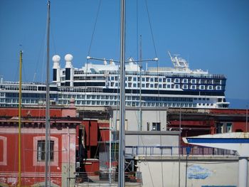 Sailboats moored at harbor against clear sky