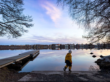 Rear view of man walking on beach against sky during winter