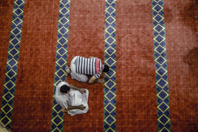 High angle view of people praying on floor in mosque