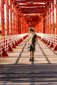 View of a boy walking on footbridge