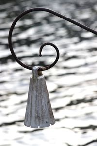 Close-up of metal chain hanging over lake