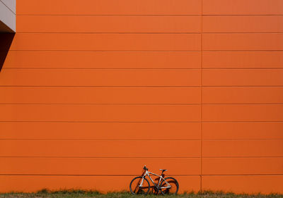 Man riding bicycle against orange sky